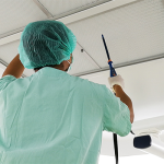 Digital anemometer, filter test. Technician using probe for testing in ceiling